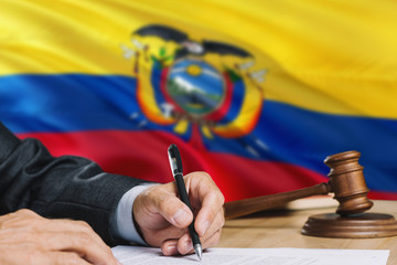 Judge writing on paper in courtroom with Ecuador flag background. Wooden gavel of equality theme...