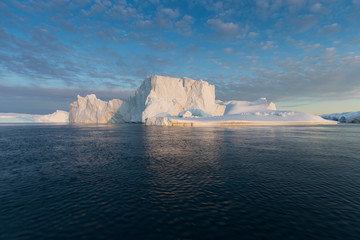 Obraz na płótnie Canvas Nature and landscapes of Greenland or Antarctica. Travel on the ship among ices. Studying of a phenomenon of global warming Ices and icebergs of unusual forms and colors Beautiful midnight sun on ship