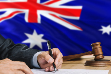 Judge writing on paper in courtroom with Heard Island and Mcdonald Islands flag background. Wooden gavel of equality theme and legal concept.