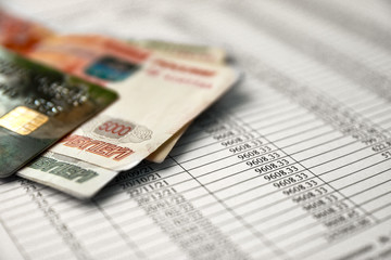Money and credit card on a loan agreement paper form with loan repayment schedule.
