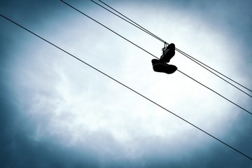 sneakers on electric wires against the sky