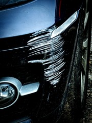 Damage to the bumper of a black car