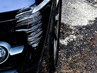 Damage to the bumper of a black car