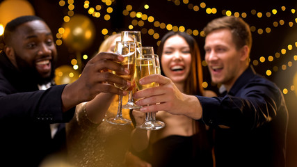 Cheerful multi-racial friends clinking champagne glasses, corporate event, fun - obrazy, fototapety, plakaty