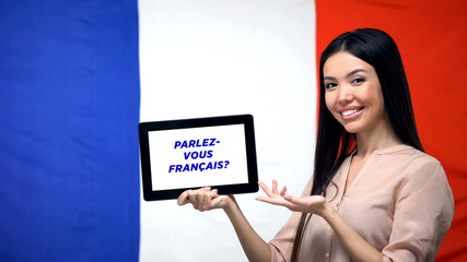 Woman holding tablet with do you speak french phrase, app for learning language