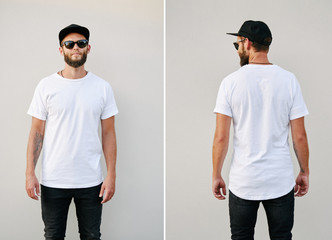 Hipster handsome male model with beard wearing white blank t-shirt and a baseball cap with space...