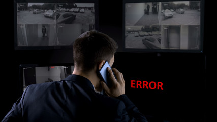 Security operator calling police, error on screen of CCTV footage, robbery