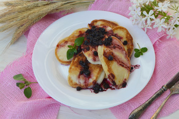 Homemade pancakes with currant jam. Russian cuisine, pink napkin on white shabby table