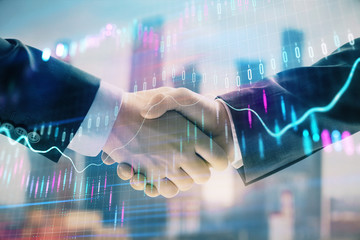 Double exposure of financial graph on cityscape background with two businessman handshake. Concept of stock market deal