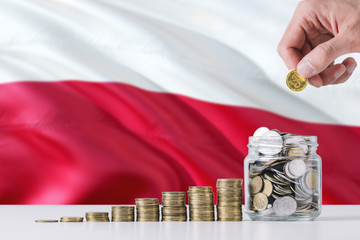 Business man holding coins putting in glass, Poland flag waving in the background. Finance and business concept. Saving money.