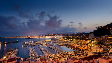 Atardecer, crepúsculo y hora azul: Vista panorámica de la ciudad de Blanes y su puerto deportivo en primer plano, Costa Brava , Girona en España