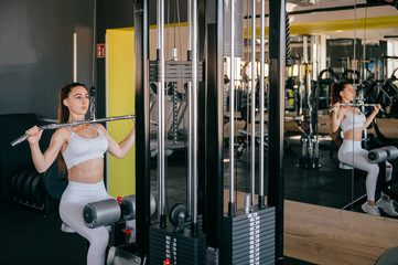 Fototapeta na wymiar Sexy fitness woman execute exercise with exercise machine in gym