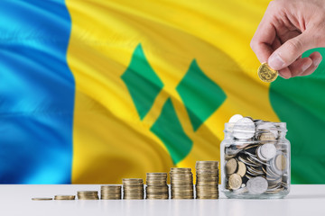Business man holding coins putting in glass, Saint Vincent And The Grenadines flag waving in the...
