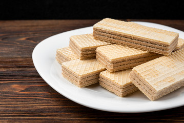 Vanilla wafer biscuit on dark wooden background.