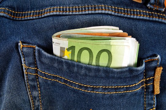 euro money cash, euro banknotes in the pockets of jeans trousers. banner for web, gift card, postcard. Concept of wealth, saving or spending money. Euro bills falling out. Easy to steal the money.