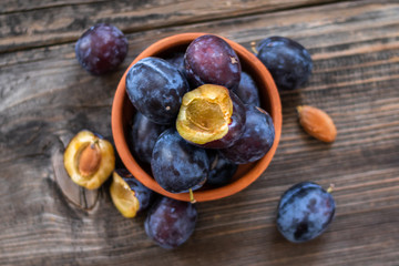 Obraz premium Fresh organic plums on old wooden table.