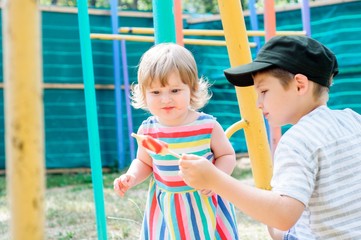Little boy with a girl eating ice cream at an outdoor cafe in outdoor cafe