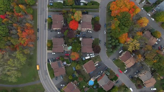 Fall in Montreal, Quebec, Canada, top-down aerial view of beautiful residential neighbourhood showing family homes and maple trees changing colour in Autumn season.