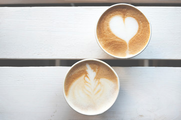 Two paper cups of coffee take-away on wooden table with copy space. Top view.