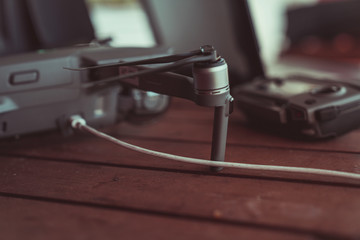 Drone quadcopter with a flight controller and notebook on the old wooden table.