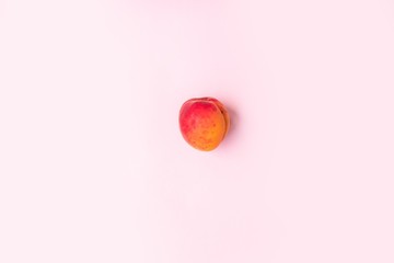 Flat composition of ripe tasty peach on a pink background.