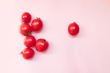 Ripe tomato on pink background. Creative concept. Square format. Top view.