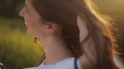 Man's hand touches the hair of his beloved. Close up Romantic couple in love kissing outdoor at bright sunny day.