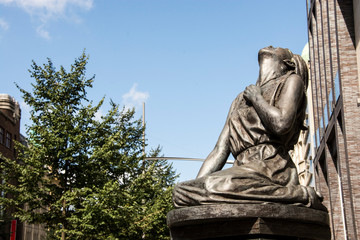 Statue of a girl praying/looking towards the sky sitting on her knees