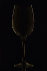 The photo shows a glass wine glass on a black background