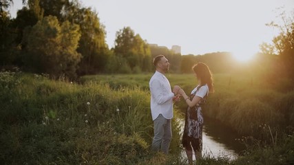 Passionate kiss couple in love at sunset by the river in the Park.