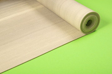 Yoga mat on green background with copyspace.