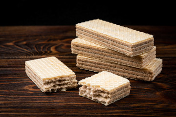 Vanilla wafer biscuit on dark wooden background.
