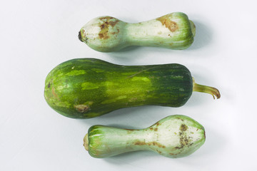 Ugly food concept. Unusual shaped zucchini with mold, scar-like structure, scratches. Top view.