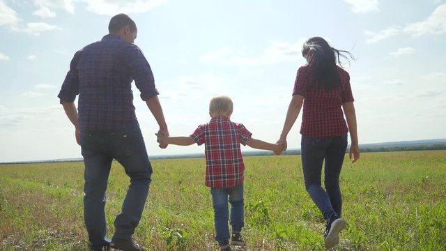 happy family walking nature teamwork friendship care concept slow motion video. father mom and son walk in nature sunset sunlight hold hand. happy family parents man and girl lifestyle hold little boy