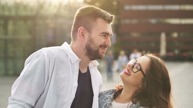 Smiling couple in love outdoors. Young happy couple hugging on the city street.