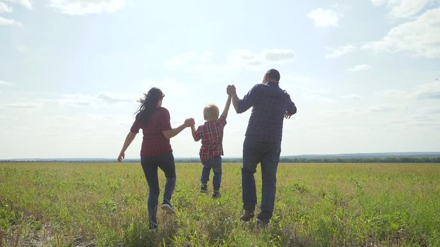 happy family runs nature teamwork friendship care concept slow motion video. father mom and son running in nature sunset sunlight hold hand. happy family parents man and girl lifestyle hold little boy
