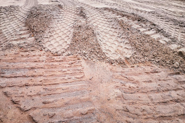 Dirty track imprints on the sand, background.
