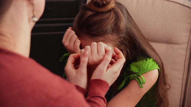 Young worried teenage girl receives comforting and hope from an adult - closeup on face and hands
