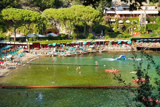 PARAGGI, LIGURIA, ITALY - AUGUST 15, 2019: Sandy Paraggi beach between the cities of Rapallo and Portofino. Vacation at a resort in Europe. Village in Tigullio Bay. Popular tourist destination