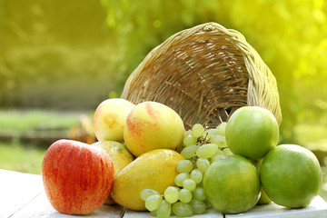 fruits in a basket. meadow, closeup. healthy organic fruits in the basket isolated on a beautiful...