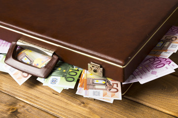 Close-up closed suitcase with banknotes inside