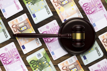 Top view judge gavel on striking block and banknotes