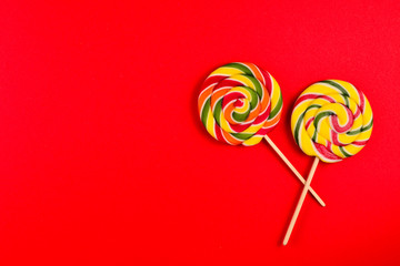 Colorful candy on a red  background. Lollipop. Top view. Copy space.