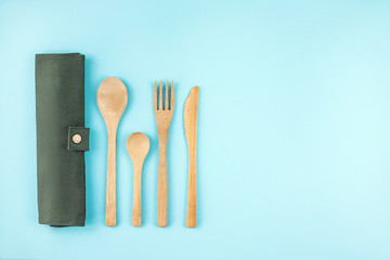 Eco friendly bamboo cutlery set on blue background.
