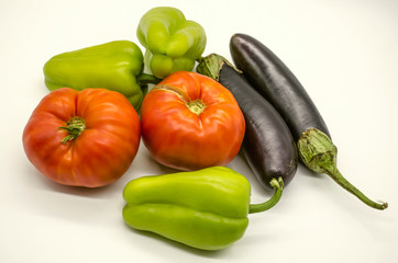 Green sweet peppers,large red tomatoes and black- purple eggplants, vegetables grown in Armenia lies on a white background