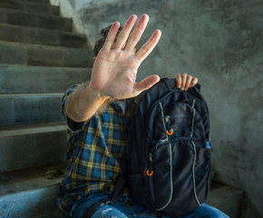 stop bullying abuse and discrimination campaign. young student man with backpack rasing hands...