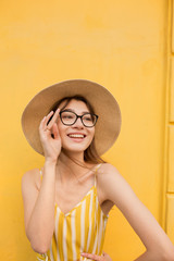 Fashion woman in stylish clothes on a background of a yellow wall. Bright photo with emotions. copy space