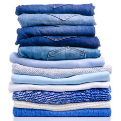 Stack folded blue shirt clothing and jeans on white background isolation