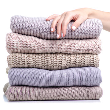 Stack folded sweater clothing hand holding on white background isolation