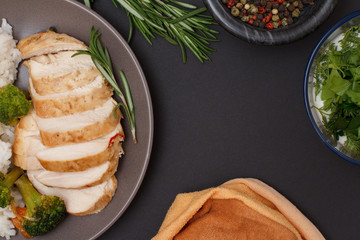 Baked chicken breasts or fillet on plate with rice and vegetables on plate.